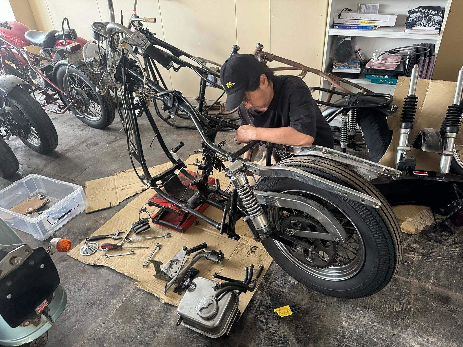 1974FXショベルヘッドの純正フレーム中央部を分解する作業。リアホイールとリアフェンダーが残った状態
