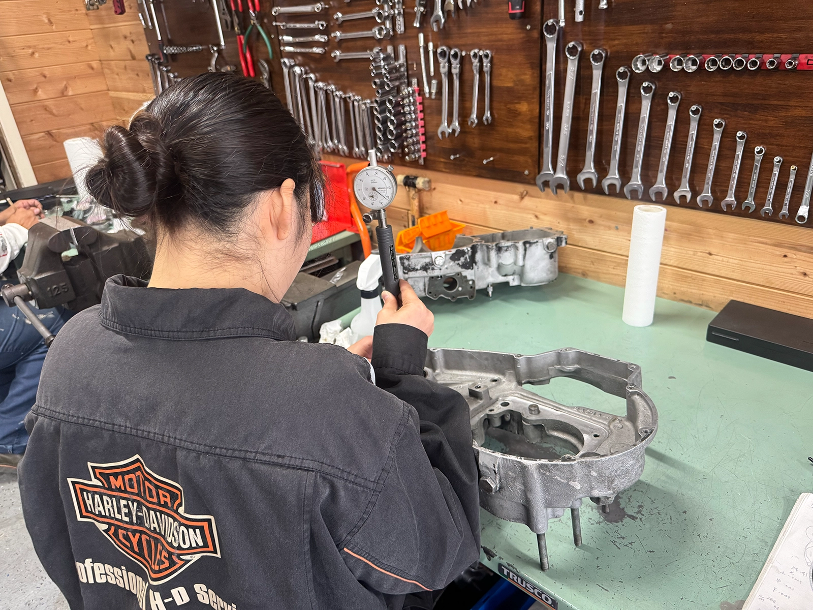 アイアンショベルのクランクケースを作業台に置き、シリンダーゲージで内径を確認する様子