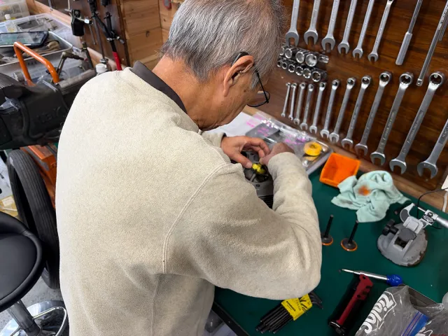 Triumph T100Tのシリンダーヘッドを作業台に置き、バルブシートカットの準備を行う様子