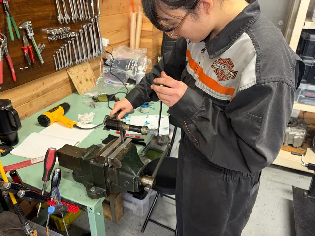 コンロッドスモールエンドブッシュの圧入位置を確認しながら工具を操作する様子